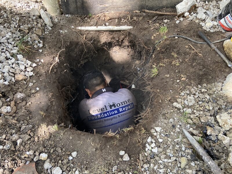 Level Home Foundation Repair crew member installing steel pier Tulsa Oklahoma foundation contractors