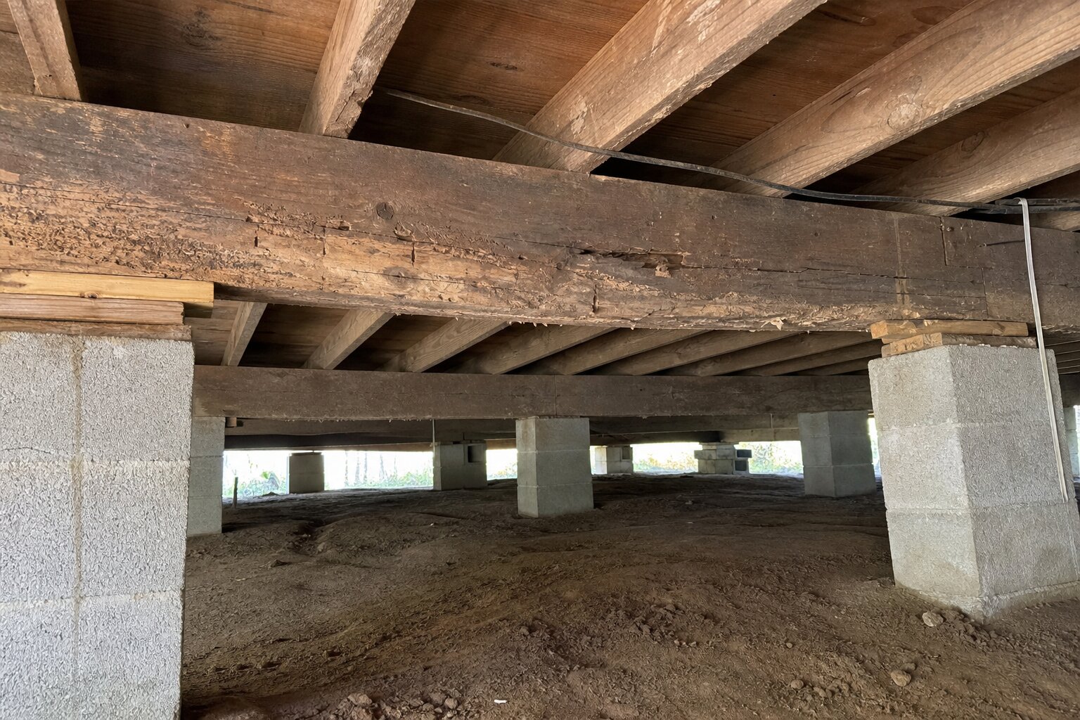 Pier and beam foundation damage showing deteriorated support beams and sagging floor joists underneath a Tulsa Oklahoma home