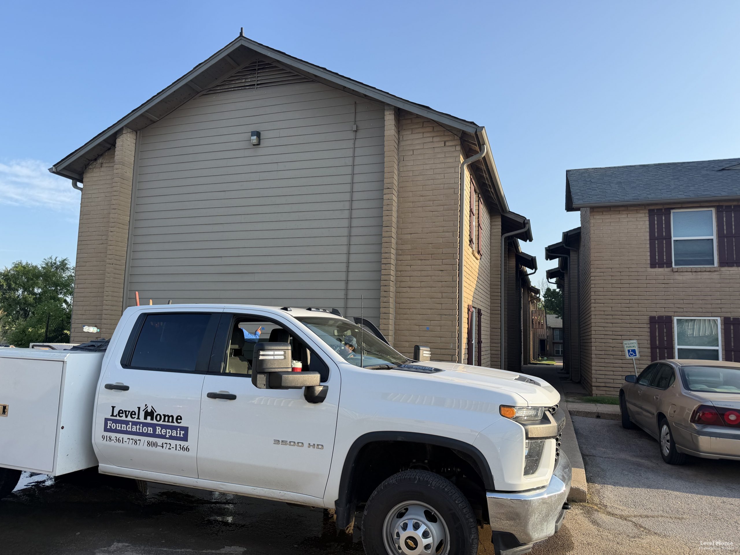 Level Home Foundation Repair truck parked at a multi-family apartment complex during a structural repair project