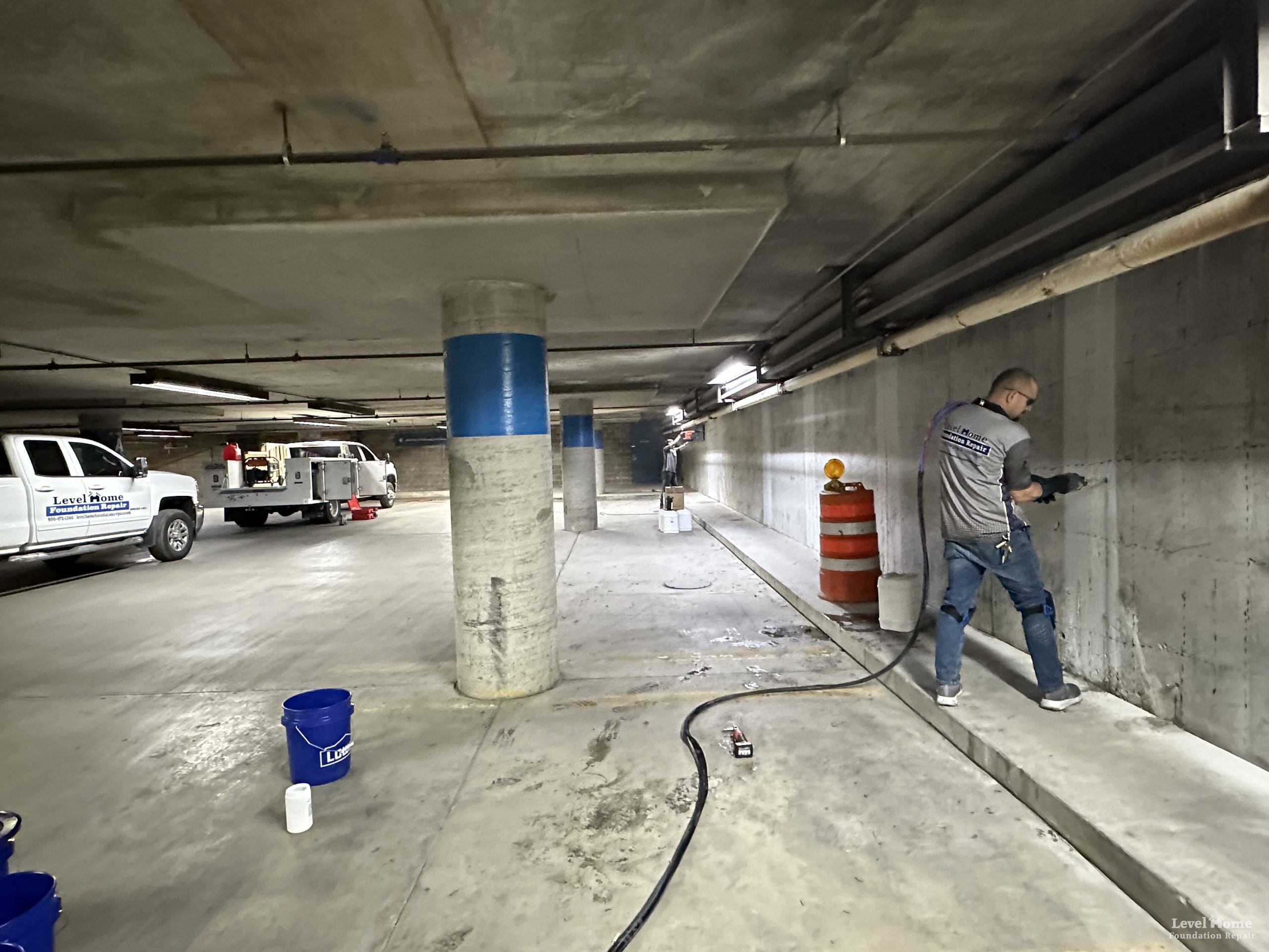 Level Structural crew performing polyurethane foam injection in a multi-story commercial parking garage