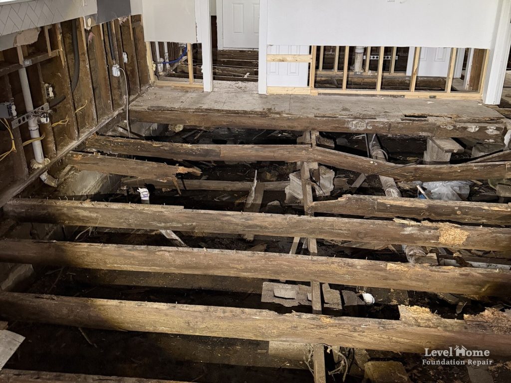 Rotted floor joists exposed above a crawl space after the subfloor was removed inside a home