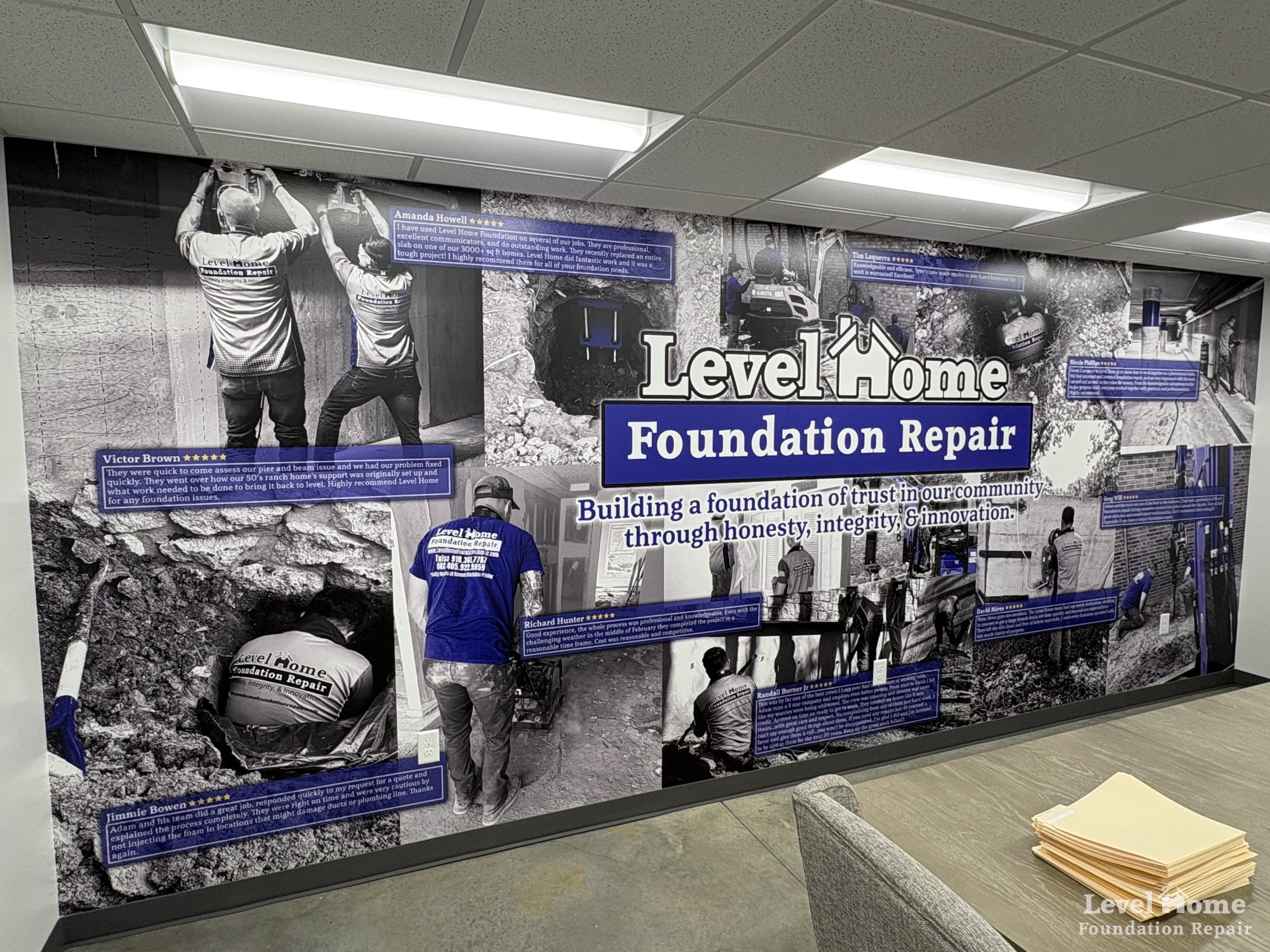 Level Home Foundation Repair office wall mural showing team at work with five star customer reviews and company mission statement building a foundation of trust in Tulsa Oklahoma